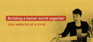 A promotional banner featuring a person working at a desk with papers and a typewriter, overlaid with the text 'Building a better world together, one website at a time' on a textured yellow background.